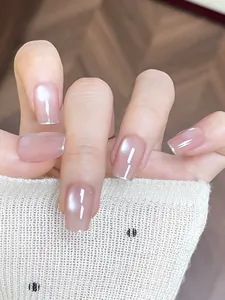 Detail of pink pearlescent handmade press-on nails with silver glitter French tips