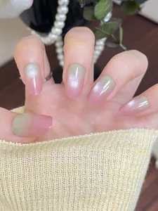 Detail of pink and green gradient press-on nails with shimmering cat eye effect