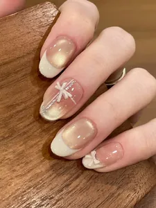 Détails d'ongles œil de chat champagne avec nœuds 3D et pointes françaises