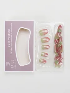 Detail of gradient pink and green cat-eye press-on nails set with glitter in purple box