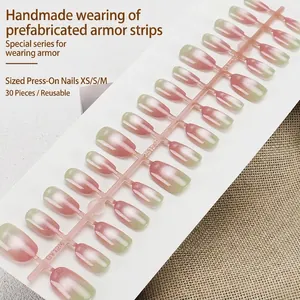 Pink and green gradient cat-eye press-on nails with glitter on a white display board