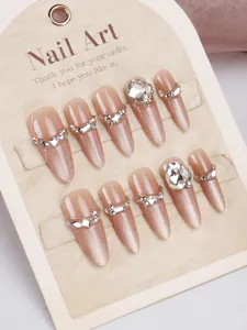 Détail macro de faux ongles œil-de-chat rose nude avec strass et pierres scintillantes