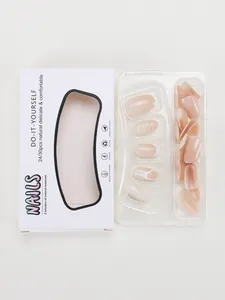 Flat lay of nude pink press-on nail set with white swirl designs in retail box