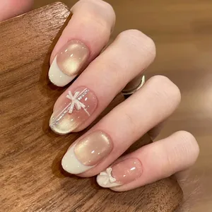 Ongles à presser faits main avec gel œil-de-chat champagne et nœuds blancs en 3D