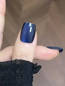 Detailed view of navy blue shimmering press-on nails with elegant cat eye effect finish