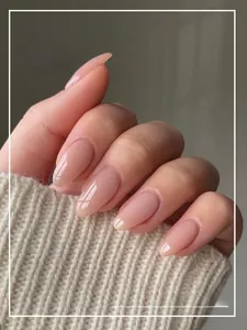 Macro detail of nude gradient press-on nails on hands with a beige sweater background