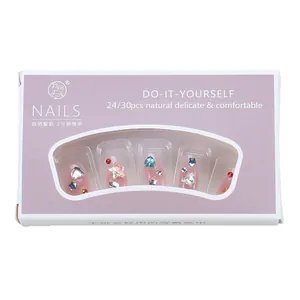 Handmade pink press-on nails with rhinestones and stars in a purple display box