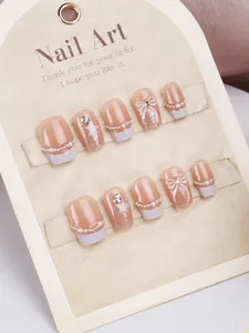 Detailed macro view of handmade pink cat-eye nails with white 3D bows and pearls