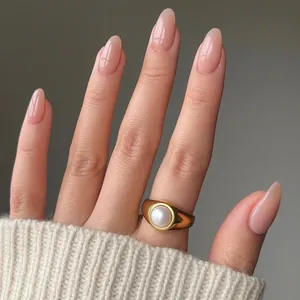 Elegant gold pearl ring paired with almond nude gradient press-on nails for women