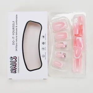Faux ongles French roses avec fleurs blanches et strass présentés dans leur boîte
