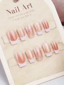 Detail of pink cat-eye press-on nails with white French tips and elegant bow accents