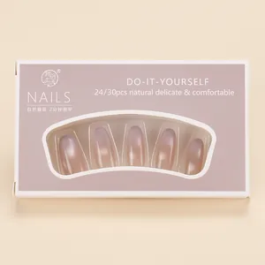 Detail view of pink and purple gradient cat-eye press-on nails in lilac packaging box