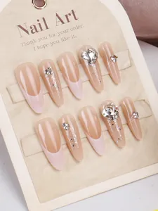 Nahaufnahme von handgefertigten Press-on-Nägeln mit 3D-Strass und silbernen Glitzerspitzen