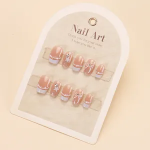 Handmade pink cat-eye press-on nails with pearls and butterfly bow tie decorations
