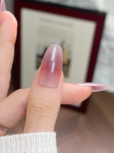 Gros plan sur ongles ovales œil de chat avec dégradé rose-violet et fini scintillant