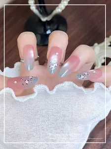 Detail of long almond press-on nails with pink gradient and rhinestone accents