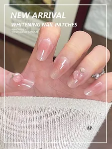 Detailed view of pink gradient press-on nails with 3D peach charms and glitter finish