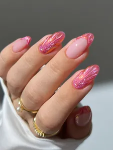 Makro-Detail von rosa Muschelnägeln mit 3D-Perlenakzenten und Polarlicht-Schimmer
