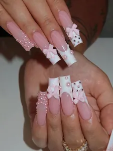 Close-up of French press-on nails with 3D pink bows, pearls and rhinestone details