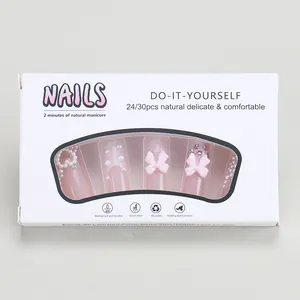 Detail of pink press-on nails with pearl hearts and bows in windowed display box