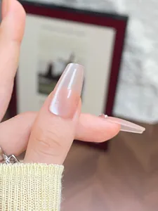 Detail of nude pink cat eye press-on nail in coffin shape with shimmering glitter finish