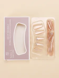 Detailed view of pink cat-eye press-on nails set with rhinestone accents in packaging