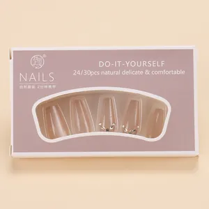 Close-up of nude cat-eye press-on nails with rhinestone accents in purple window box