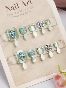 Detail van mintgroene cat-eye kunstnagels voor tenen met kristallen en lovertjes