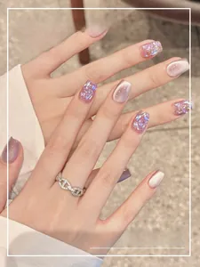 Close-up of glitter purple and cat-eye short square press-on nails with silver ring