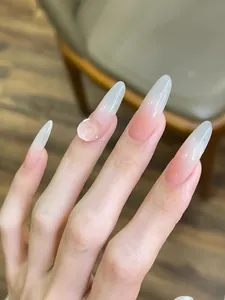 Close-up of nude pink ombre almond press-on nails featuring a 3D resin rose flower detail