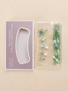 Close-up van mintgroene cat eye kunstnagels voor tenen met blauwe strassteentjes