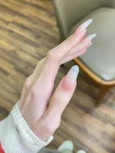 Macro detail of glossy almond-shaped long press-on nails with natural pink ombre finish