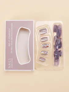 Close-up of purple glitter press-on nails set in retail packaging with clear tray