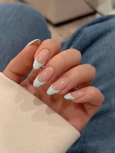 Close-up of 3D wave textured French tip press-on nails with blue relief design