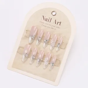 Elegant long pointed press-on nails with nude gradient, silver rhinestones and 3D white flowers