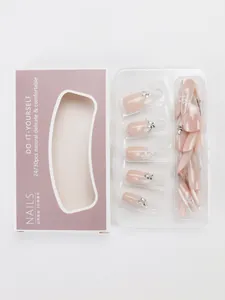 Close-up of nude gradient press-on nails with silver floral rhinestones and packaging