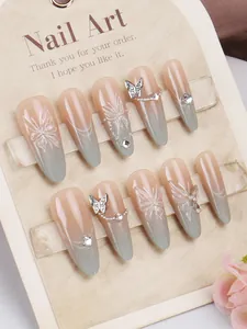 Detailed view of handmade long almond press-on nails with butterfly charms and rhinestones