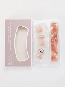 Detailweergave van de French press-on nagels met witte tips en roze strassteen accent
