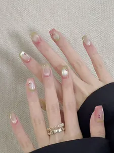 Close-up of pink and green gradient cat-eye press-on nails with shiny rhinestones