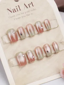 Close-up of cat-eye press-on nails with gradient morandi colors and rhinestone accents