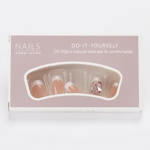 Korte French tip kunstnagels met roze strass-steentjes in een vensterdoosje