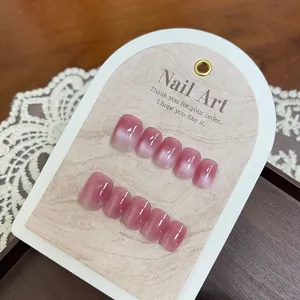 Short pink gradient cat-eye press-on nails set displayed on a lace and wood background