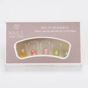 Vue détaillée des faux ongles pastel avec pois orange et dégradé de couleurs douces