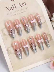 Detail van handgemaakte roze luipaard kunstnagels met 3D-strikjes en parels
