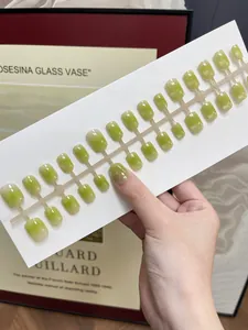 Nahaufnahme hellgrüner Cat-Eye-Nägel zum Aufdrücken in verschiedenen Größen, glänzend