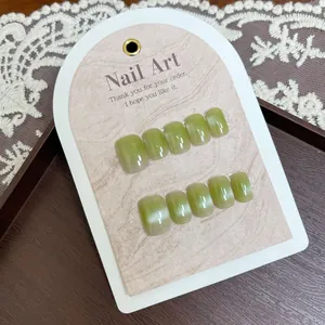 Cat-Eye-Nägel mit grasgrünem Farbverlauf und Glanzfinish auf eleganter Displaykarte