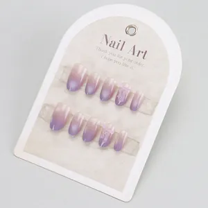 Purple cat eye gradient press-on nails with 3D bow design on a white display card