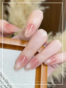 Dettaglio di unghie press-on occhio di gatto rosa nude con sfondo di fiori secchi