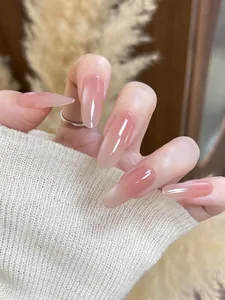 Detail of long almond press-on nails with nude pink gradient and high gloss cat eye finish