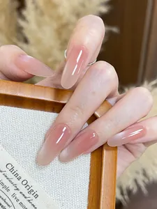 Macro view of long almond press-on nails with pink gradient and glossy cat-eye finish